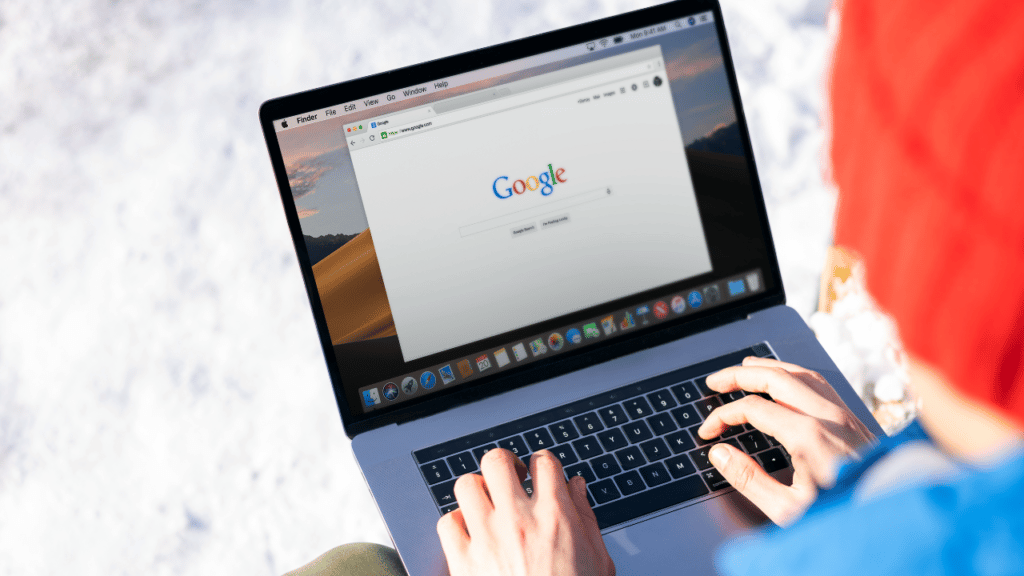 Person typing on laptop computer into Google search
