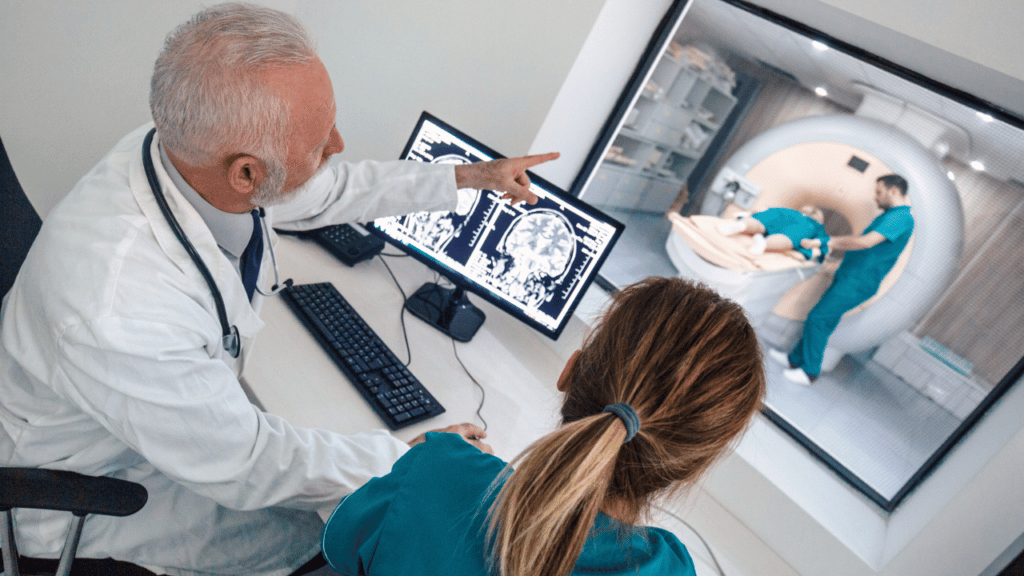 A doctor reviewing MR results with a nurse while a nurse helps a patient in the background go through an open MRI machine