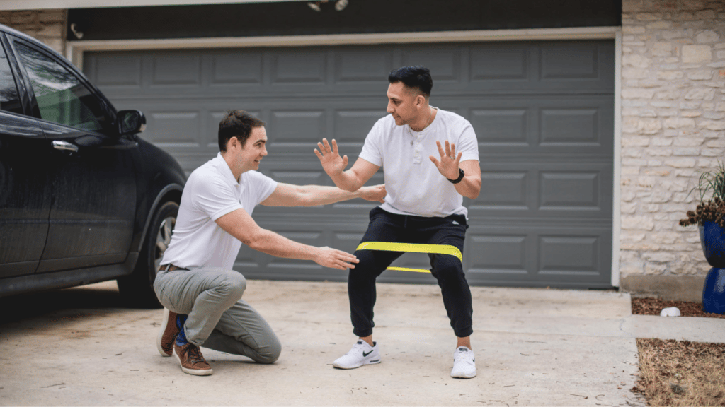 Physical Therpaist Eric Finger working with a patient using an exercise band around their legs