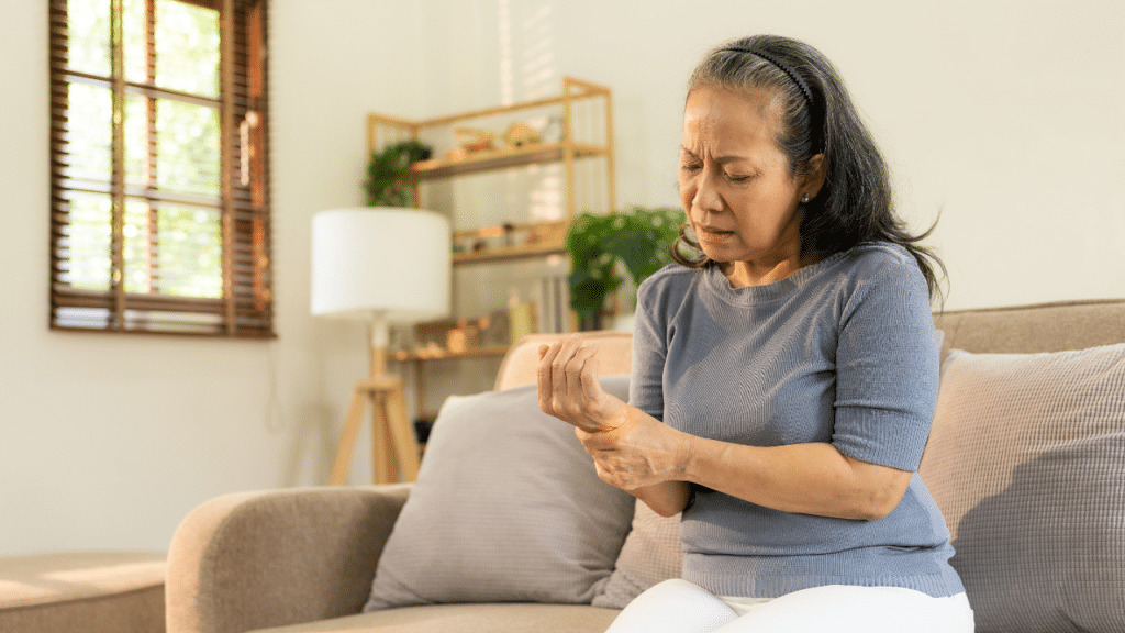 Woman holding wrist, looking at it in pain from neuropathy