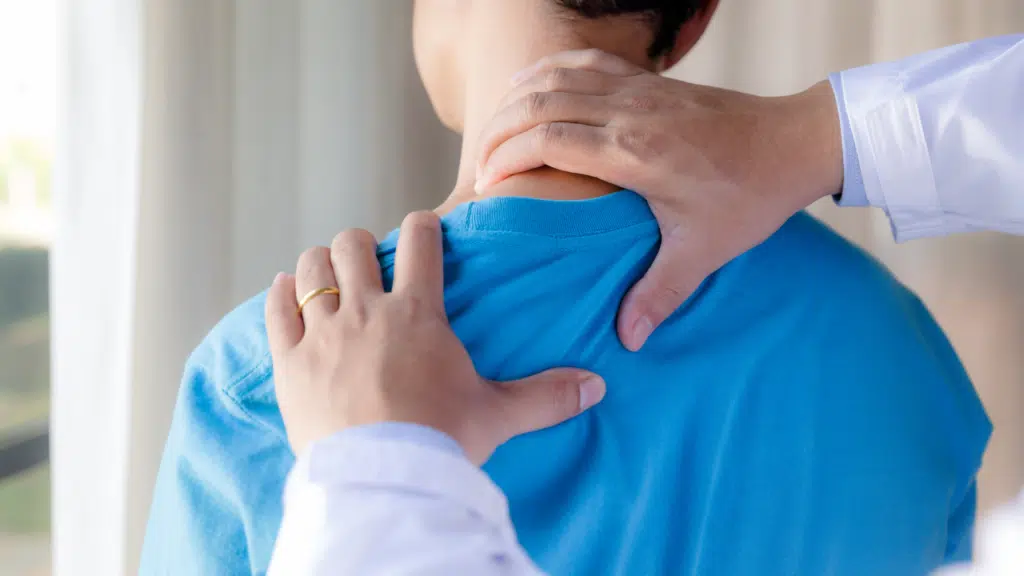 Physical therapist using manual therapy on man's neck for a herniated disc