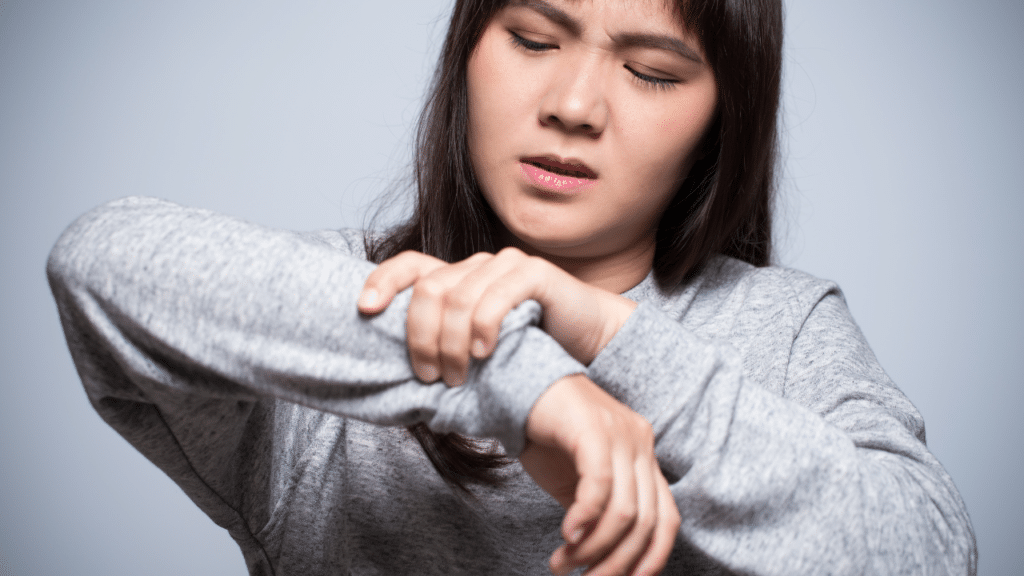 Woman holds her wrist in pain, wondering What Is Peripheral Neuropathy?