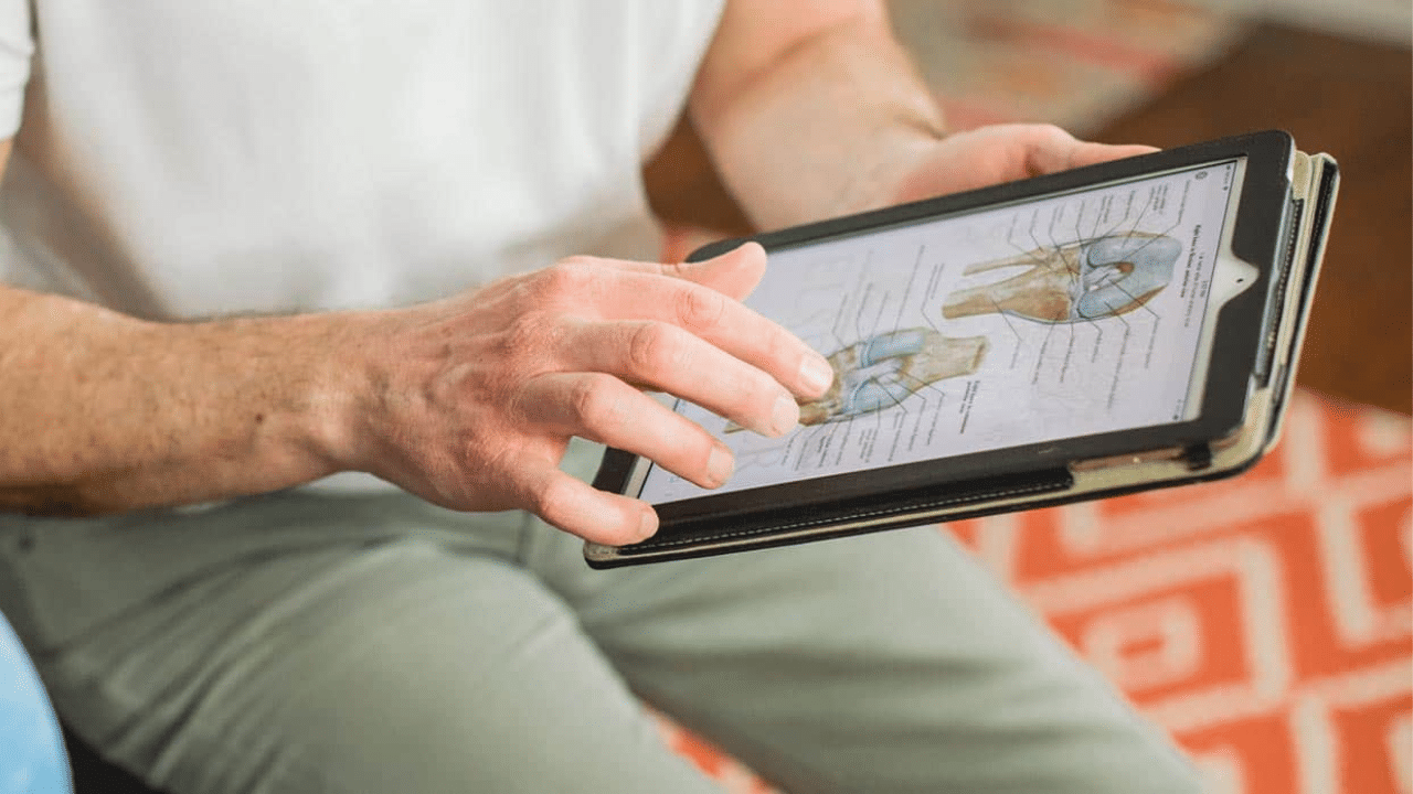 Physical therapist shows patient what is causing their pain in order to explain how Therapeutic Exercises Physical Therapists Use to Help You Heal at Home
