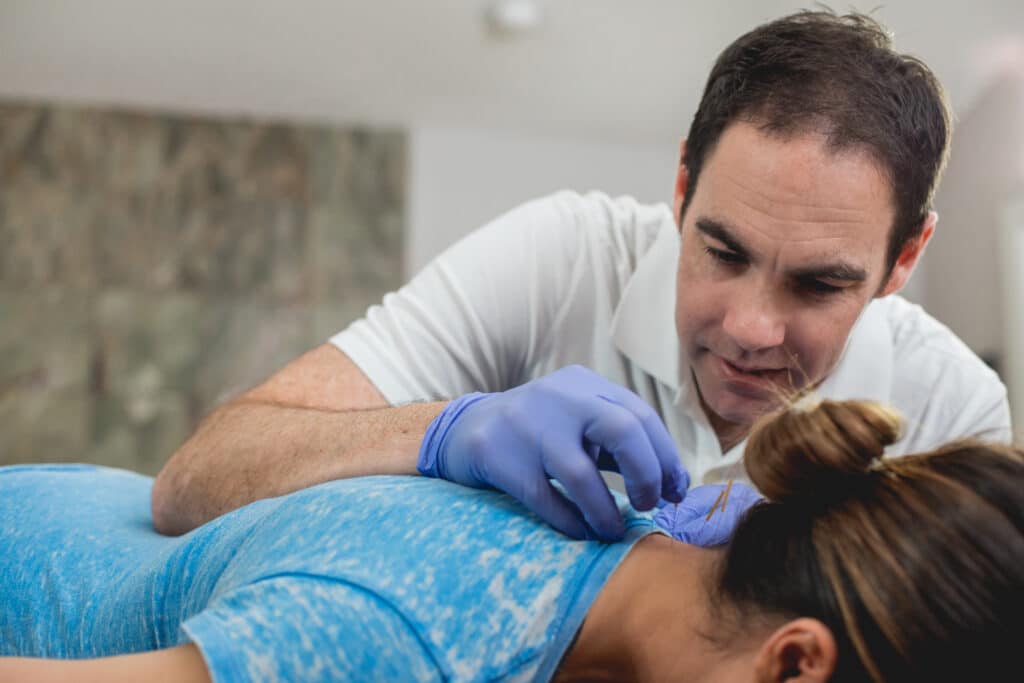 Eric Finger, founder of Move Empower Concierge Physical Therapy in Austin, TX does dry needling on a patient