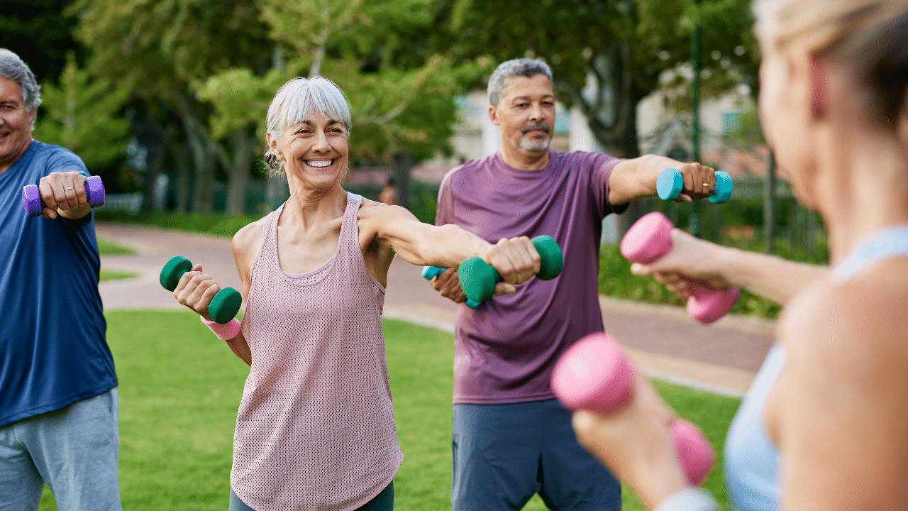 Men and women lifting weights in the park while learning Why Strength Training in Older Women Matters in Austin