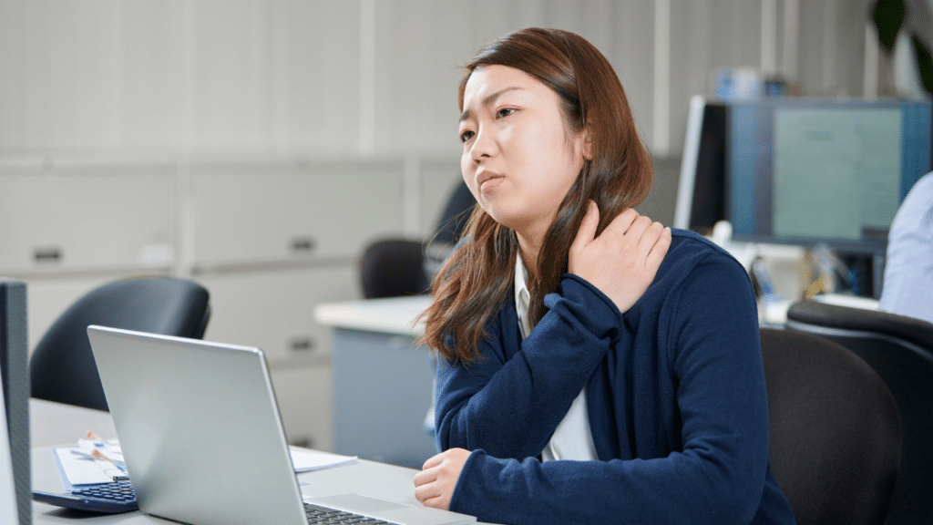Woman holding shoulder in pain wondering Could Your Shoulder Blade Pain Be A Cervical Disc Herniation?