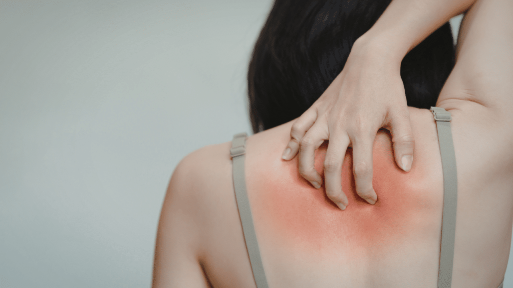 Woman holds neck in pain wondering how Your Shoulder Blade Pain Could Be A Rib Or Thoracic Spine Problem