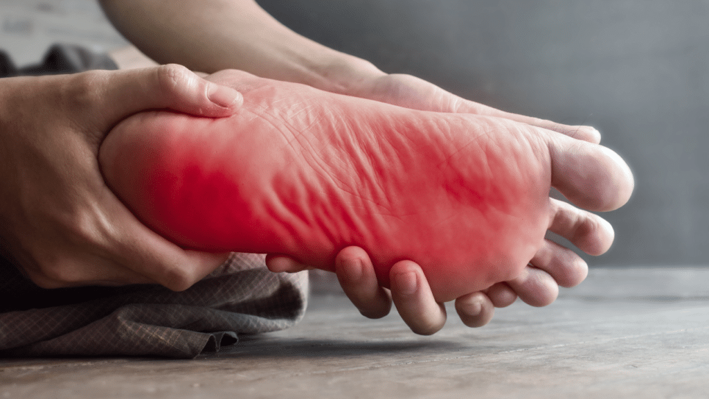 Person holds singular foot in pain wondering about Neuropathy FAQs for an Austin, TX physical therapy team