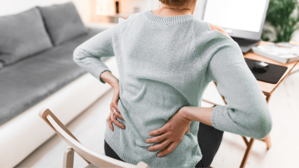 Woman holds back in pain caused by hip issues and wonders what the difference is in Loading Versus Stretching for Hip Flexors