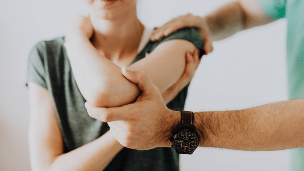 Austin, TX physical therapist examines a patient's shoulder and elbow