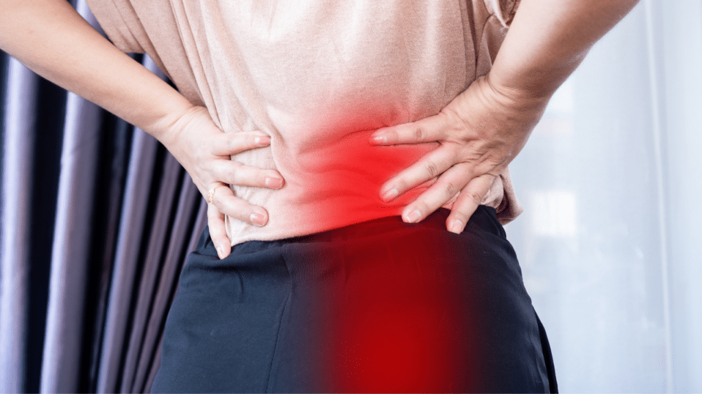 person holds back in pain, wondering How Shockwave Therapy Helps Sciatica Pain